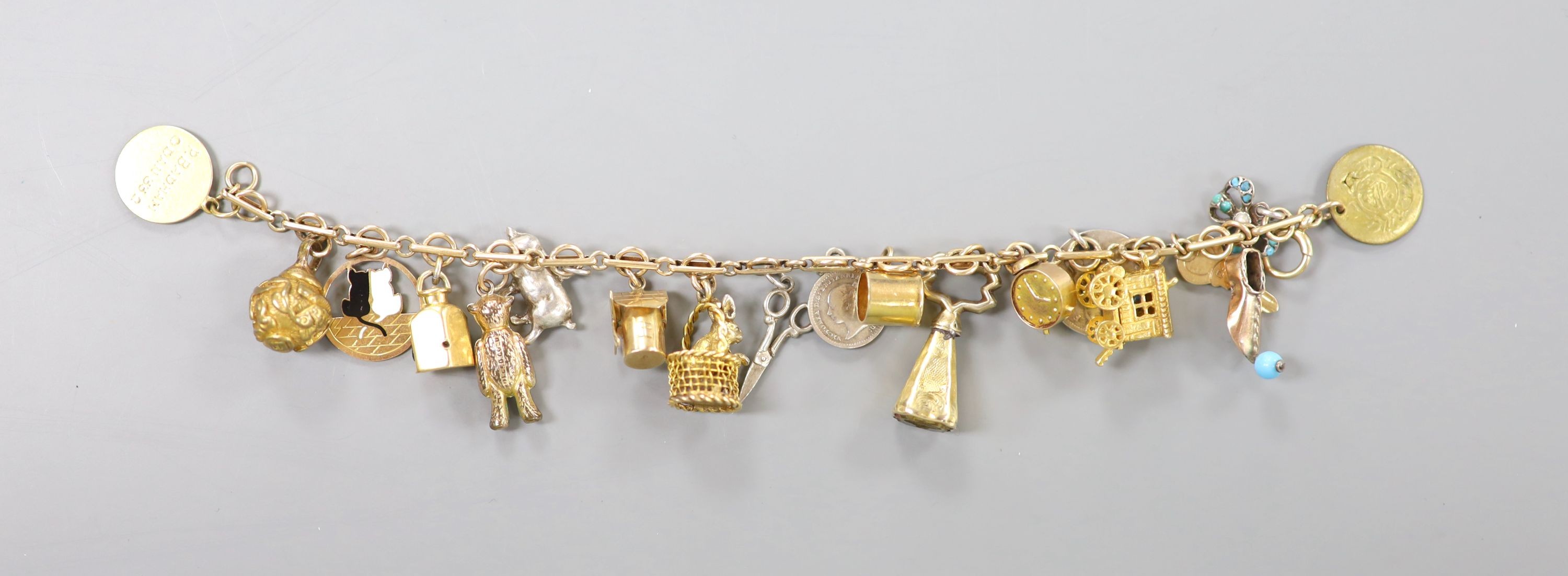A 9ct charm bracelet, hung with assorted charms, gross weight 38.1 grams.